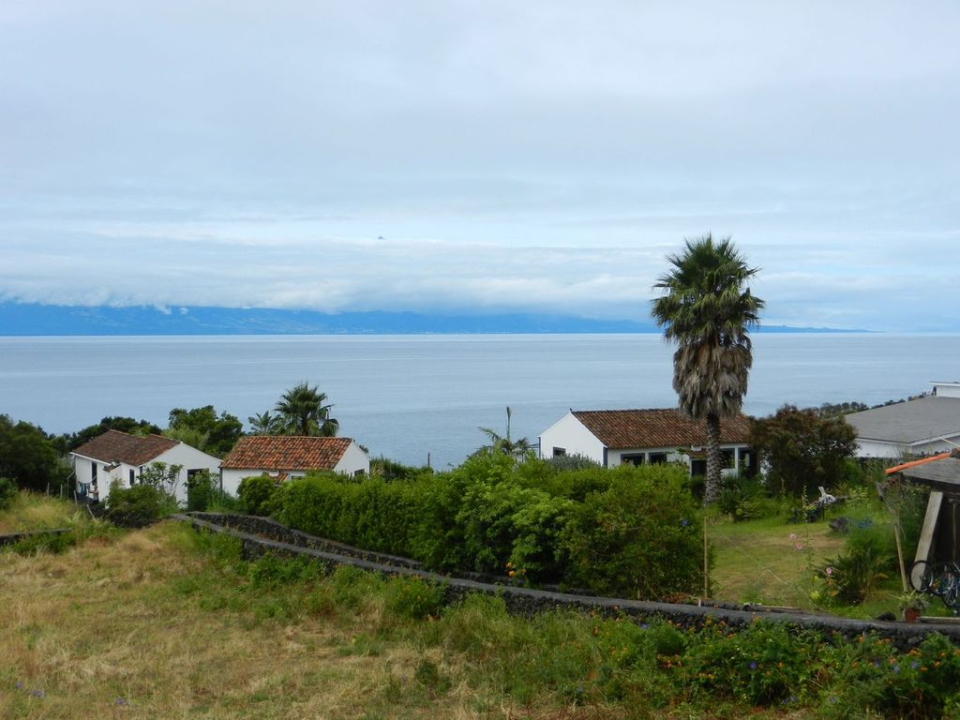 Our Bed & Breakfast on S&atilde;o Jorge: Jardim do Triângulo (we had the leftmost cabin). Above the clouds you can catch a glimpse of the peak  of mount Pico